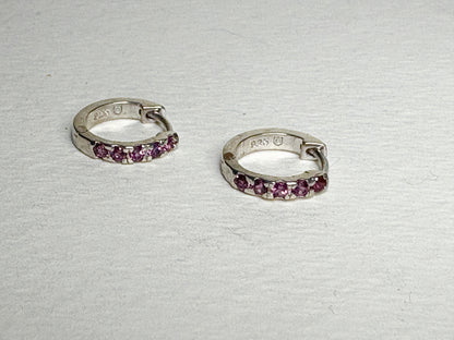 Sterling silver small huggie hoop earrings with rhodolite garnets.