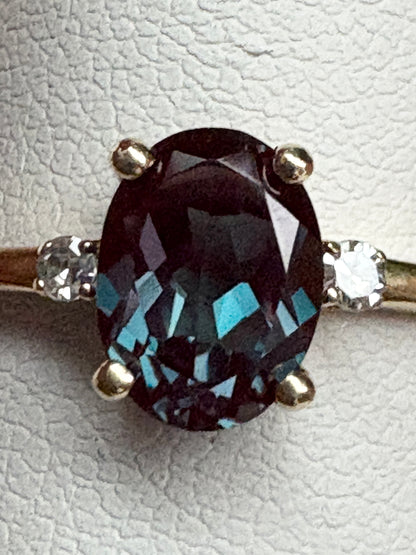 Oval lab grown alexandrite and diamond ring in 10k gold.