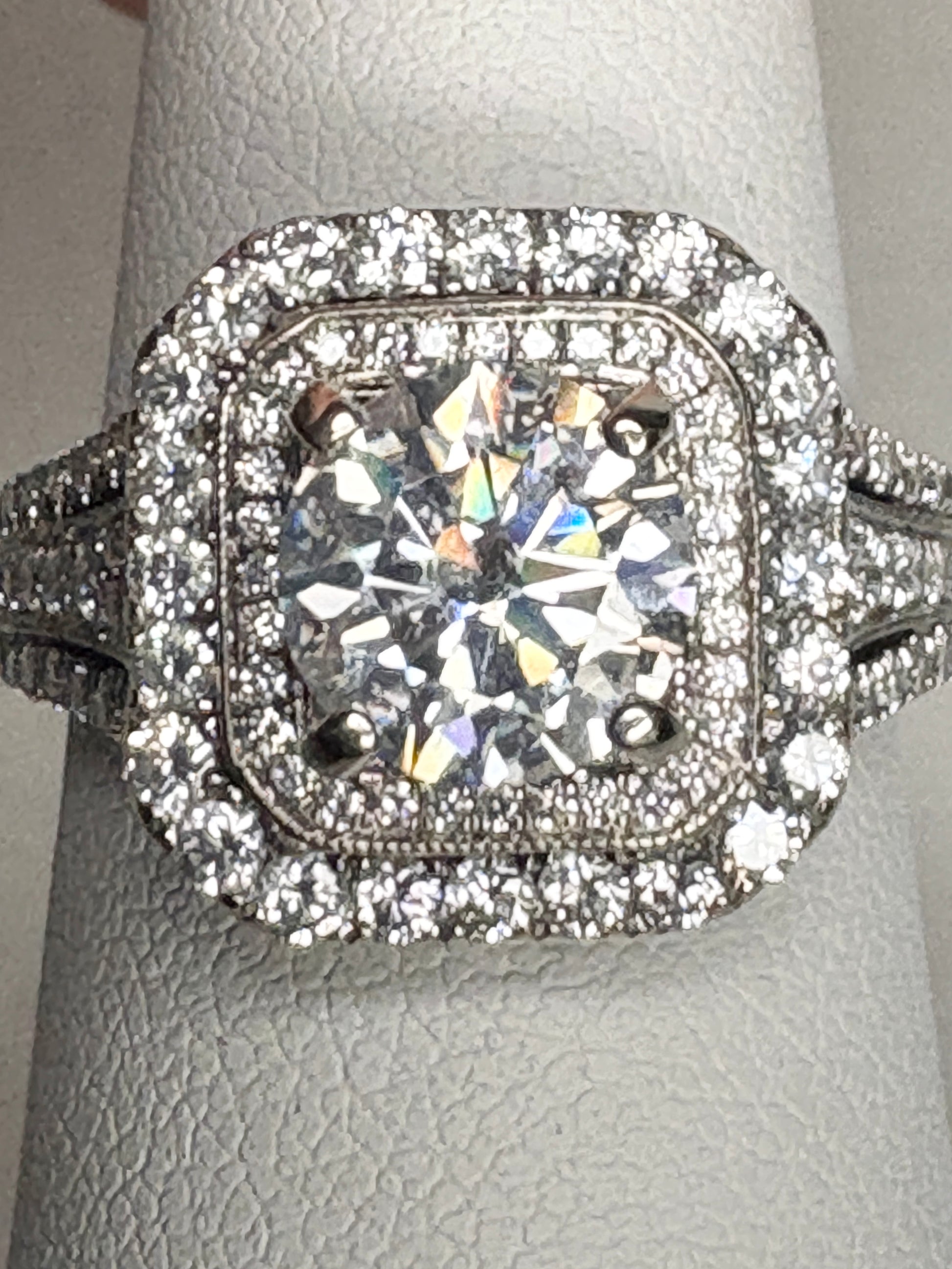 A 14k white gold ring with a large center stone and a double halo of natural diamonds.