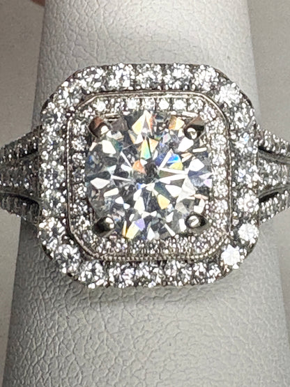 A 14k white gold ring with a large center stone and a double halo of natural diamonds.