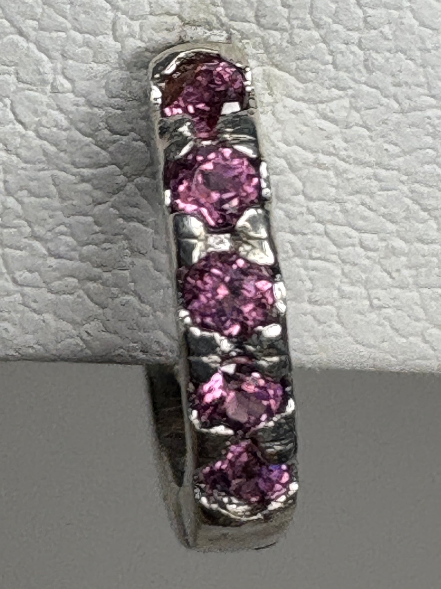 Sterling silver huggie hoop earrings with small rhodolite garnets.