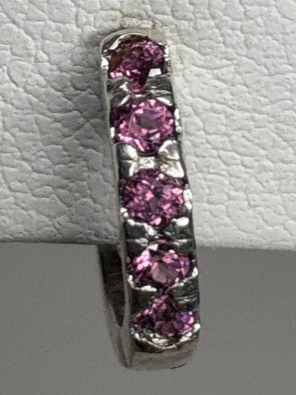 Sterling silver huggie hoop earrings with small rhodolite garnets.