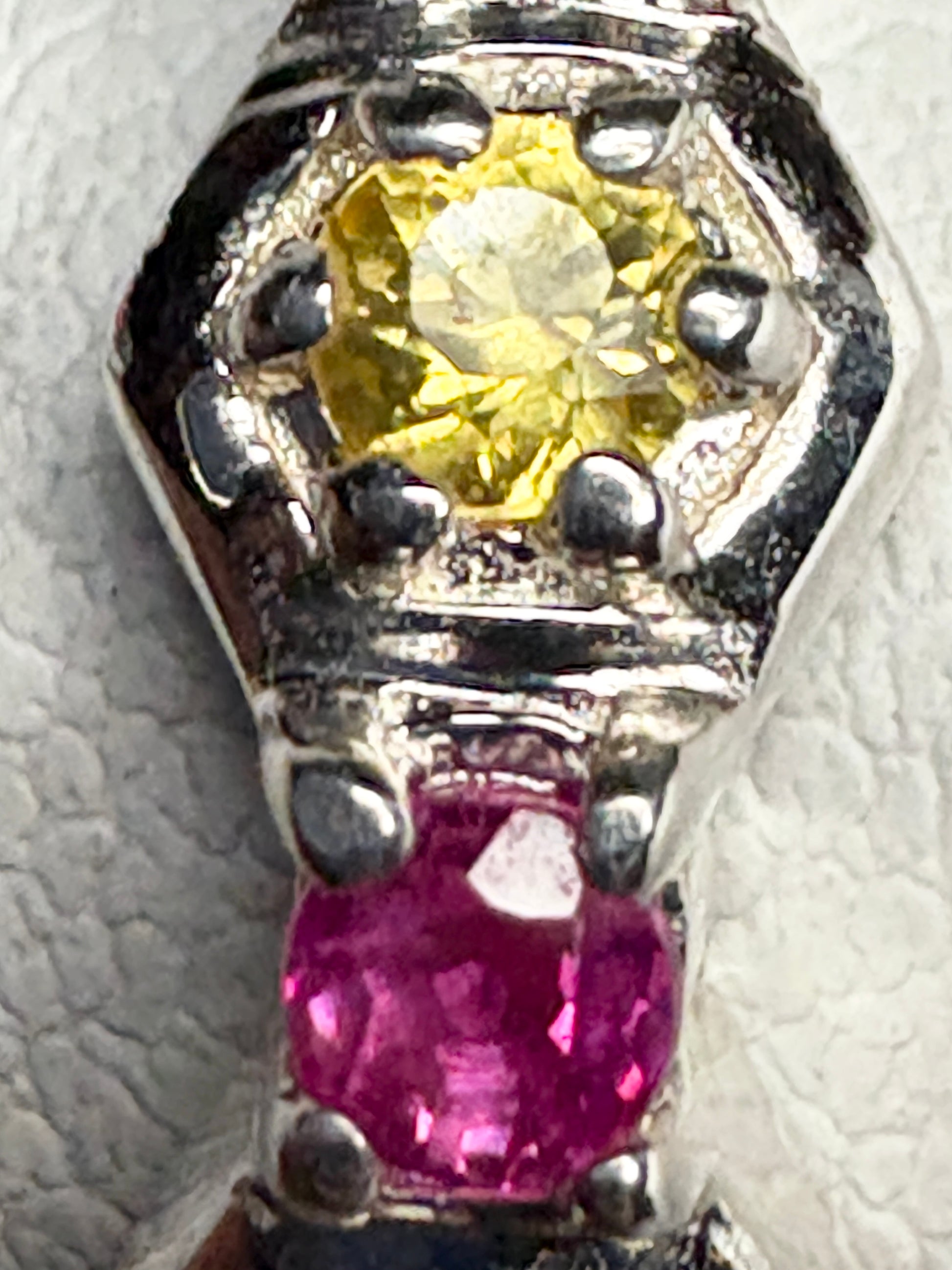 Sterling silver ring with honeycomb pattern, featuring a yellow sapphire and a pink ruby.