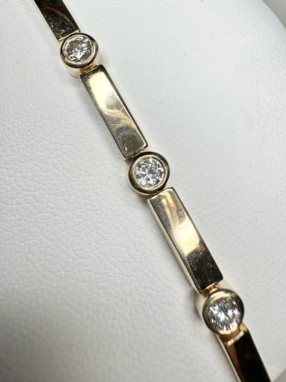 14k yellow gold tennis bracelet with bezel-set diamonds.