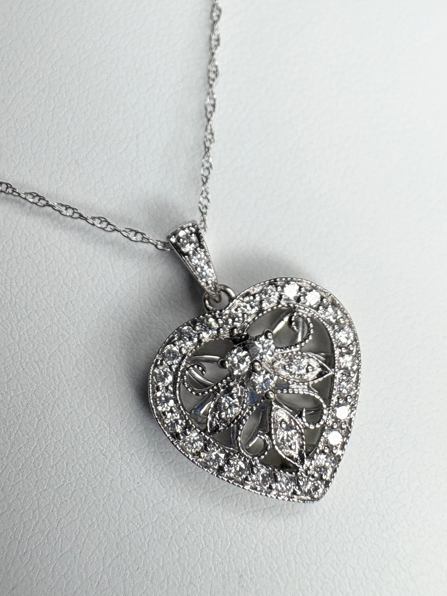 A white gold heart pendant necklace with natural diamonds.