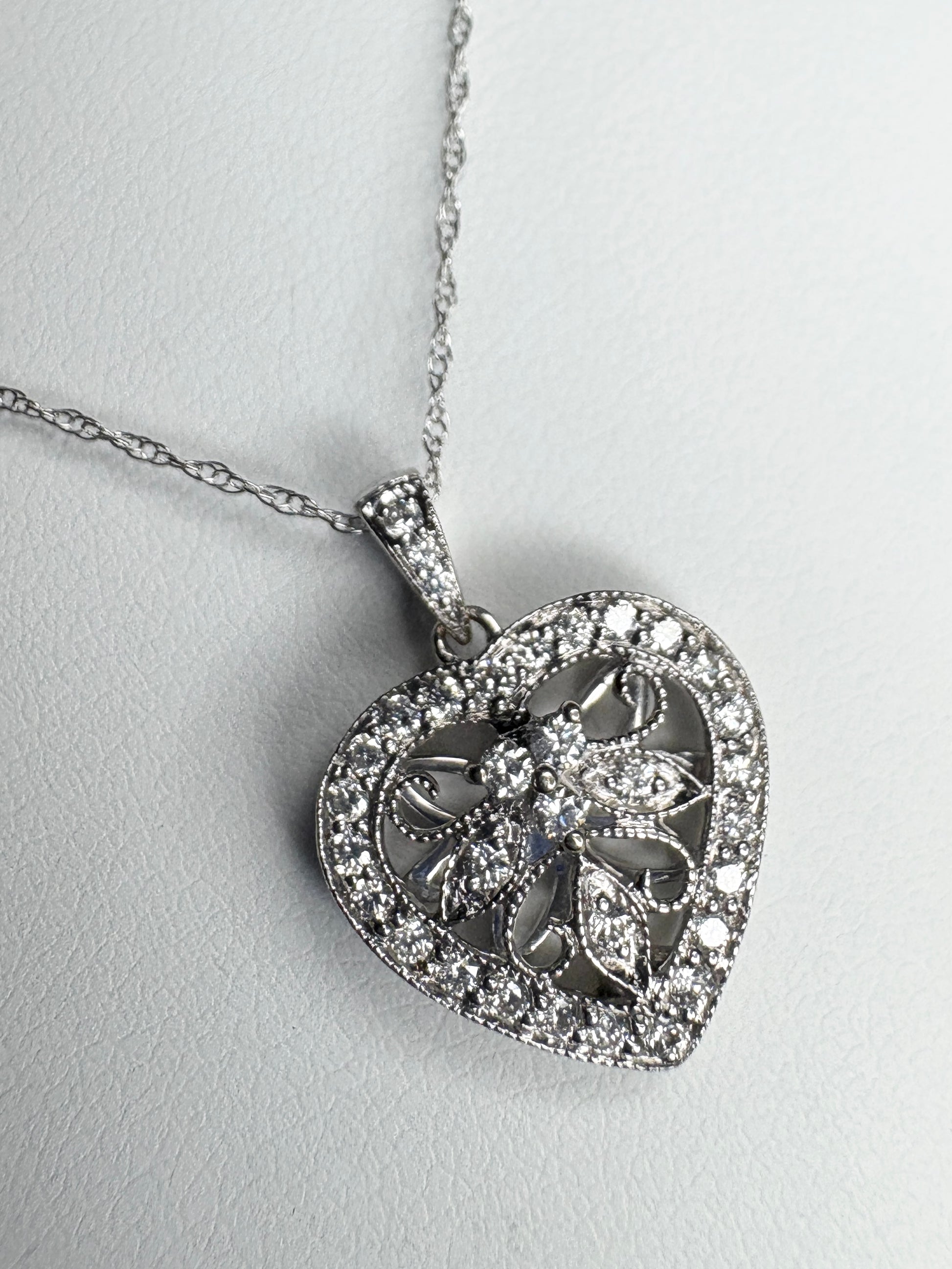 A white gold heart pendant necklace with natural diamonds.