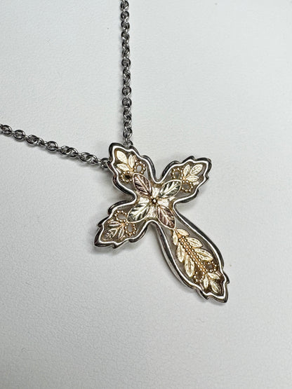 Black Hills Gold ornate cross pendant with sterling silver frame and stainless steel chain.
