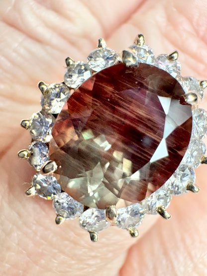 Large oval dichroic Oregon sunstone ring with diamond halo in 14k gold.