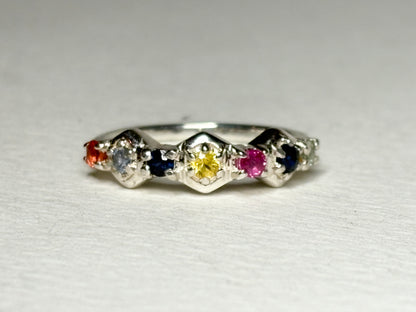 Sterling silver band ring with honeycomb shapes and multi-colored sapphires and ruby.