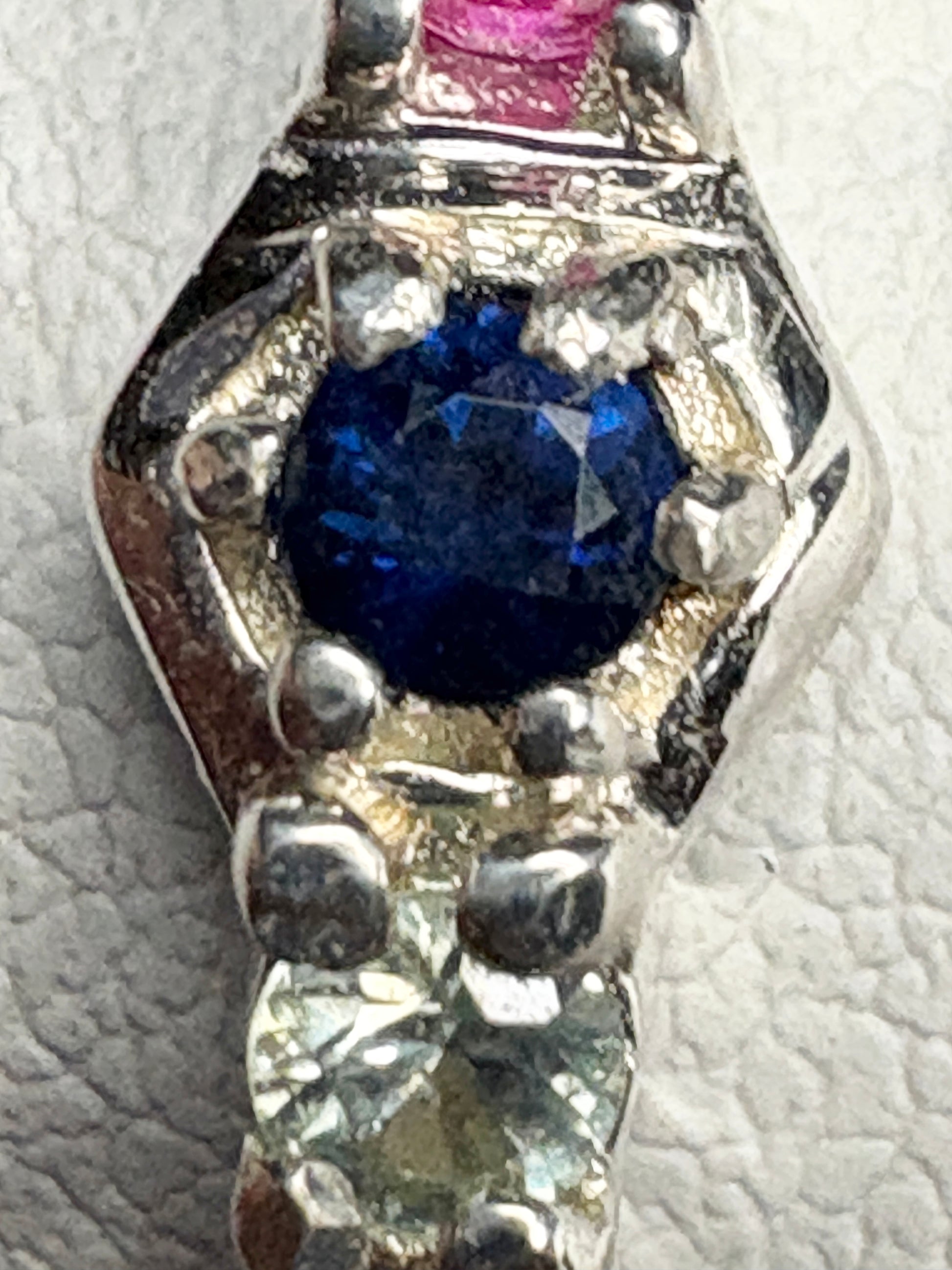 Sterling silver band ring with multi-colored sapphires and ruby in honeycomb pattern.