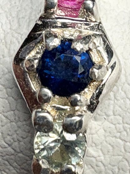 Sterling silver band ring with multi-colored sapphires and ruby in honeycomb pattern.