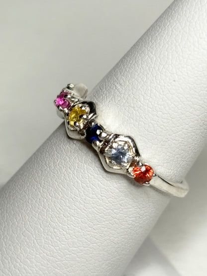 Sterling silver band ring with multi-colored sapphires and ruby in honeycomb shapes.
