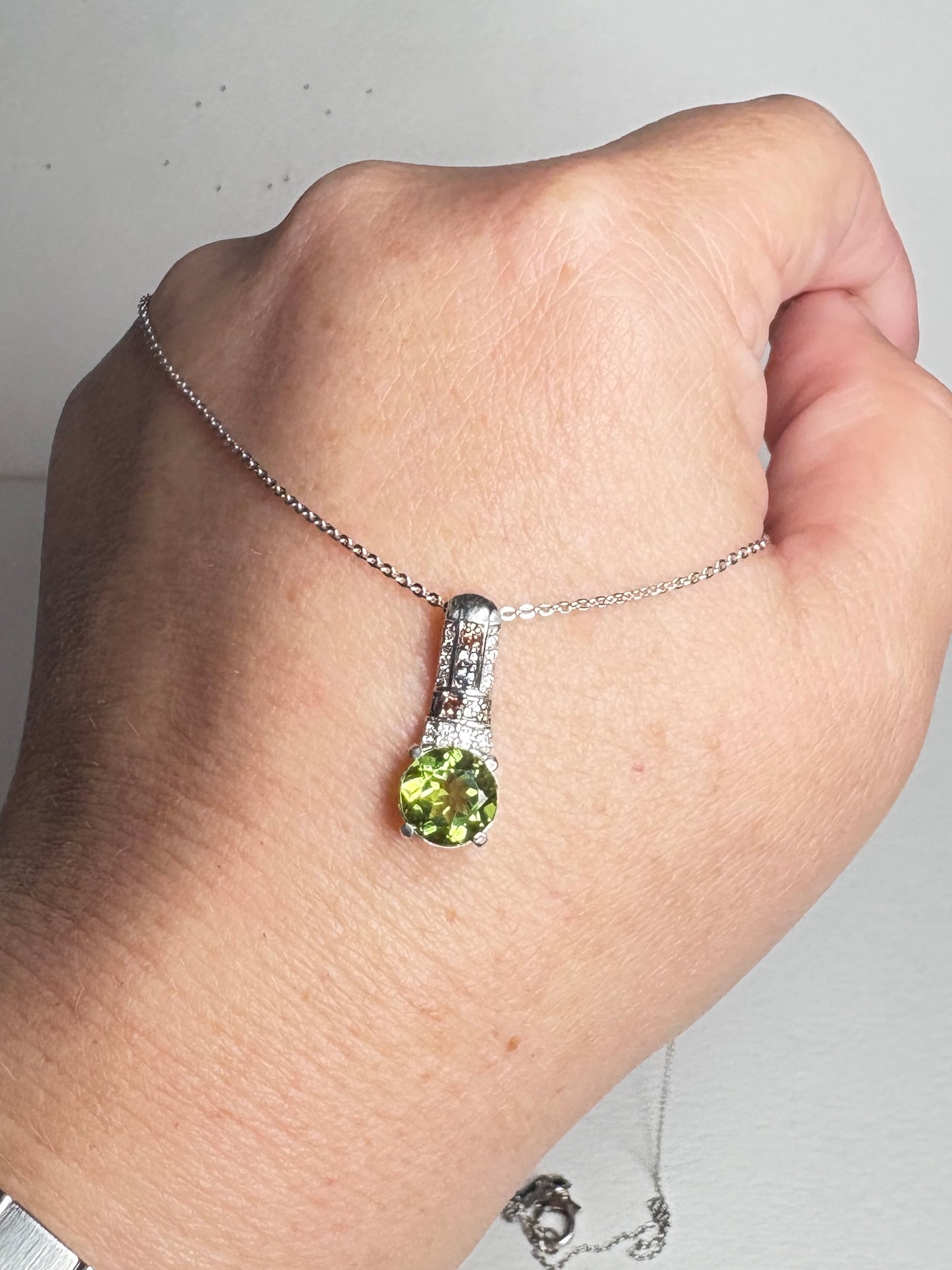 Sterling silver pendant necklace with a color-changing glass stone, moissanite, and multi-color sapphires.