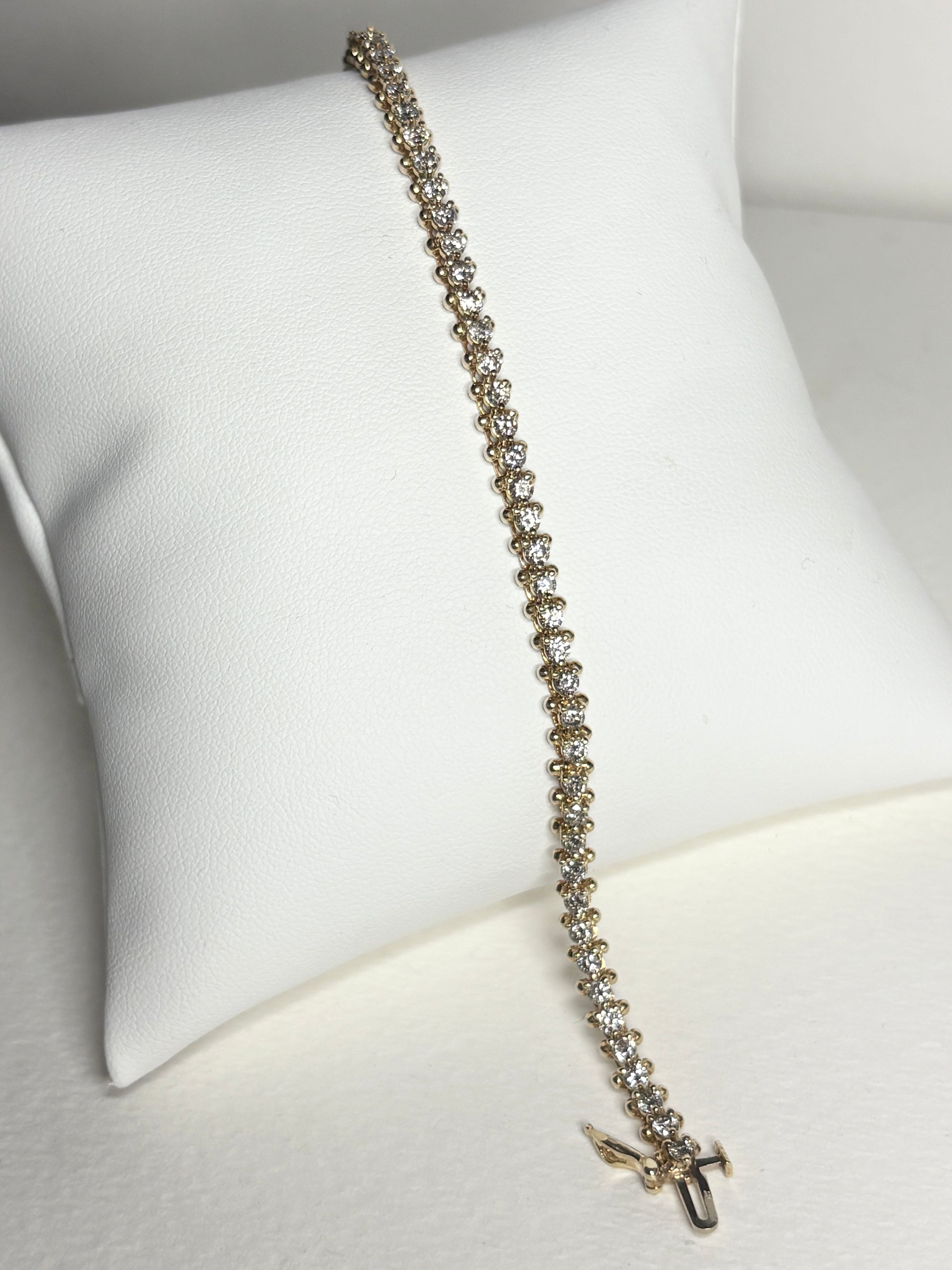 Diamond tennis bracelet in solid 14k gold with 57 round diamonds.