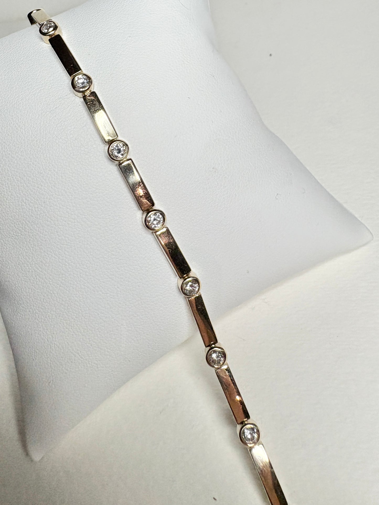 14k yellow gold tennis bracelet with 11 bezel-set diamonds.