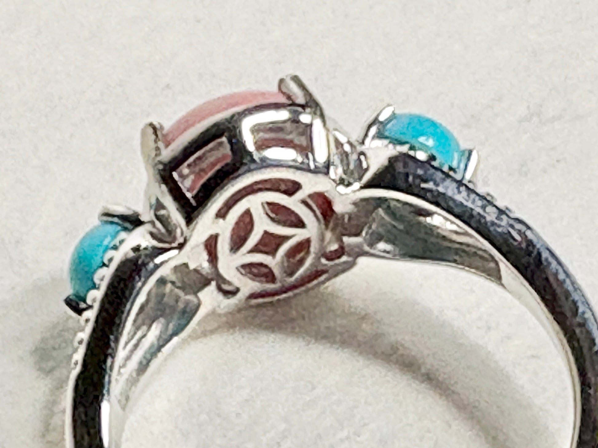 Sterling silver ring with oval peach opal and round turquoise cabochons.