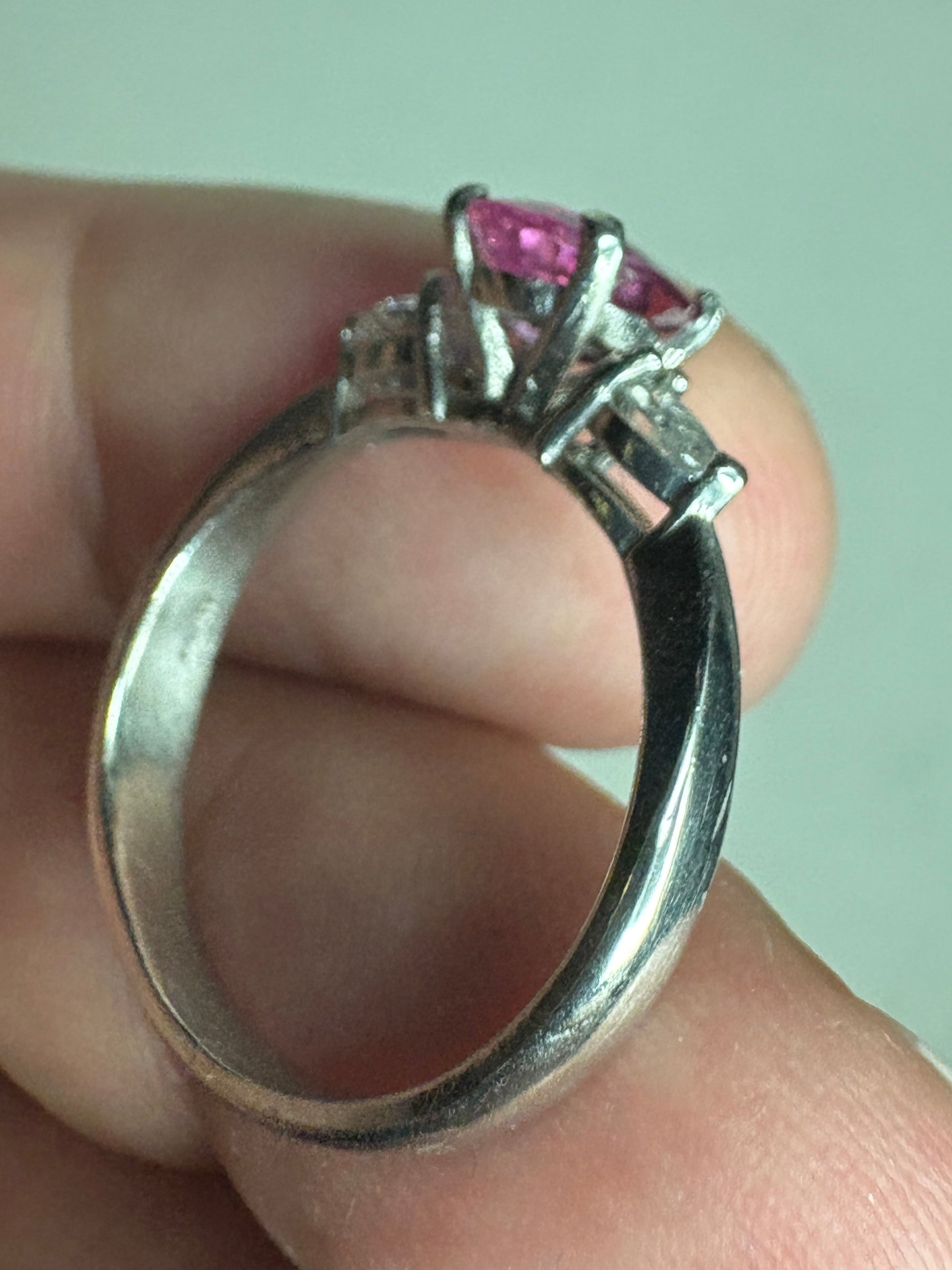 Platinum ring with a pink sapphire and pear-shaped diamonds.
