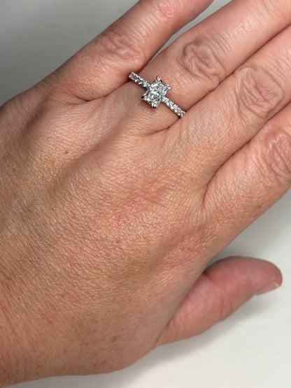A 14k white gold engagement ring with a rectangular diamond and accent stones.