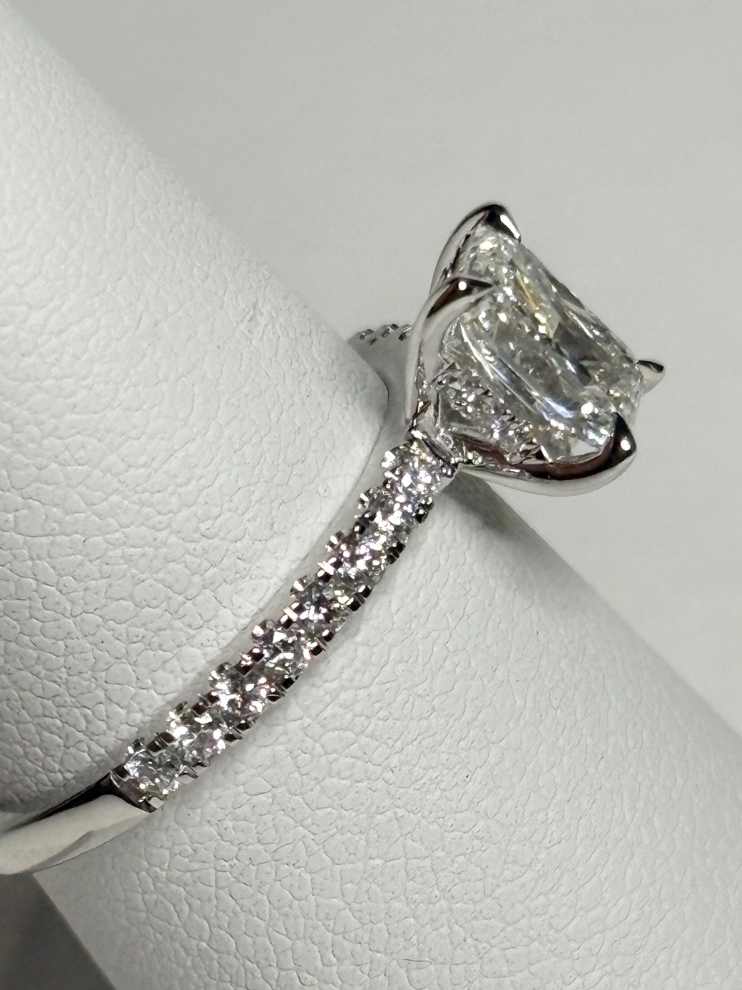 A 14k white gold engagement ring with a large center diamond and smaller diamonds on the band.