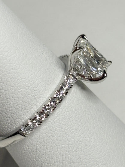 A 14k white gold engagement ring with a large center diamond and smaller diamonds on the band.