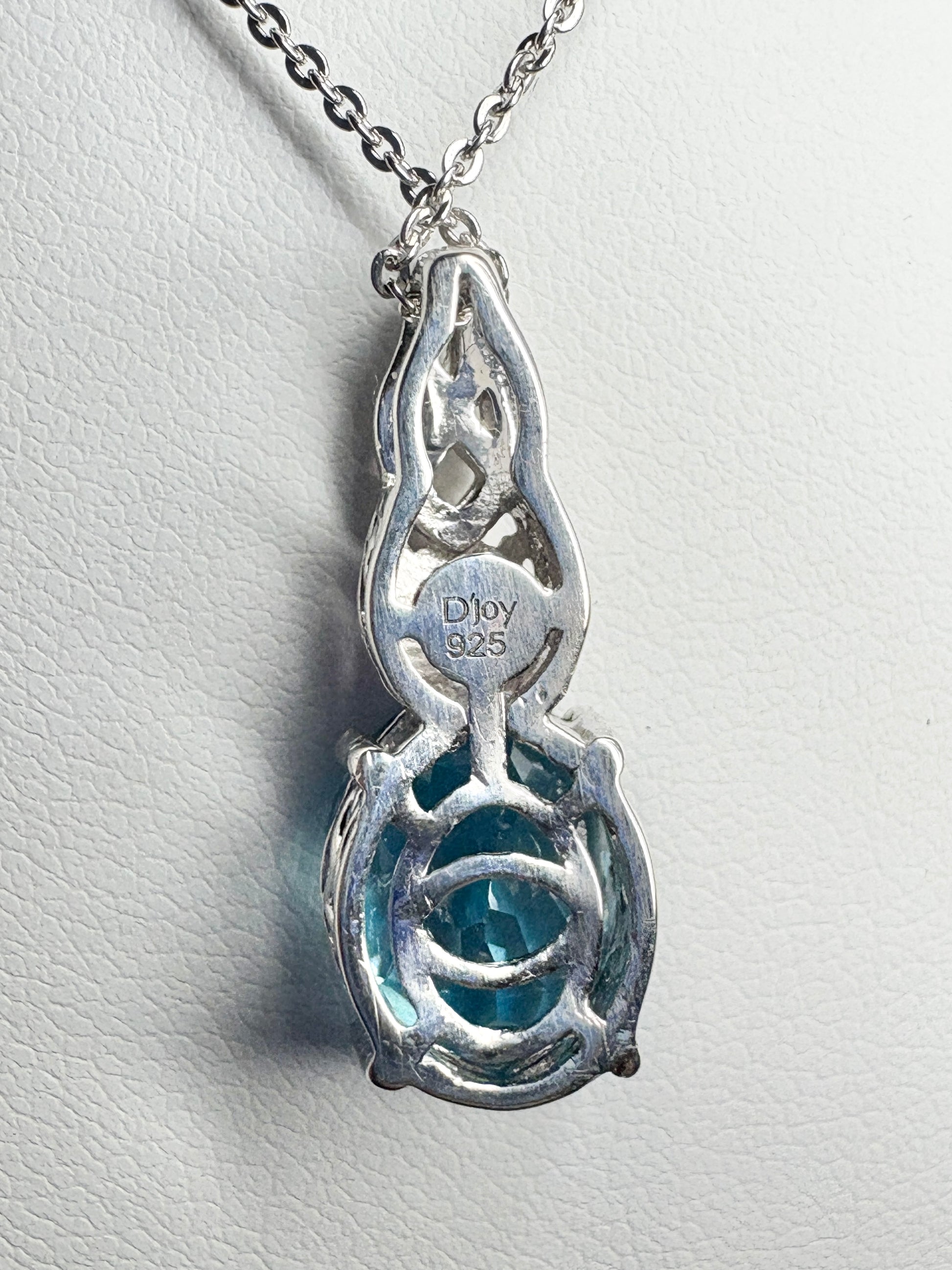 Sterling silver pendant necklace with a blue topaz and rhodolite garnet.