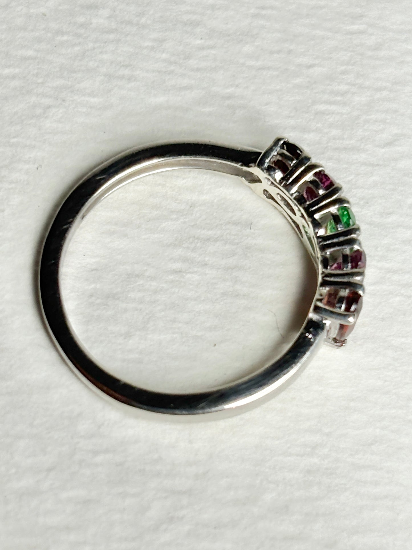 Sterling silver band ring with alternating almandine, rhodolite, and tsavorite garnets.