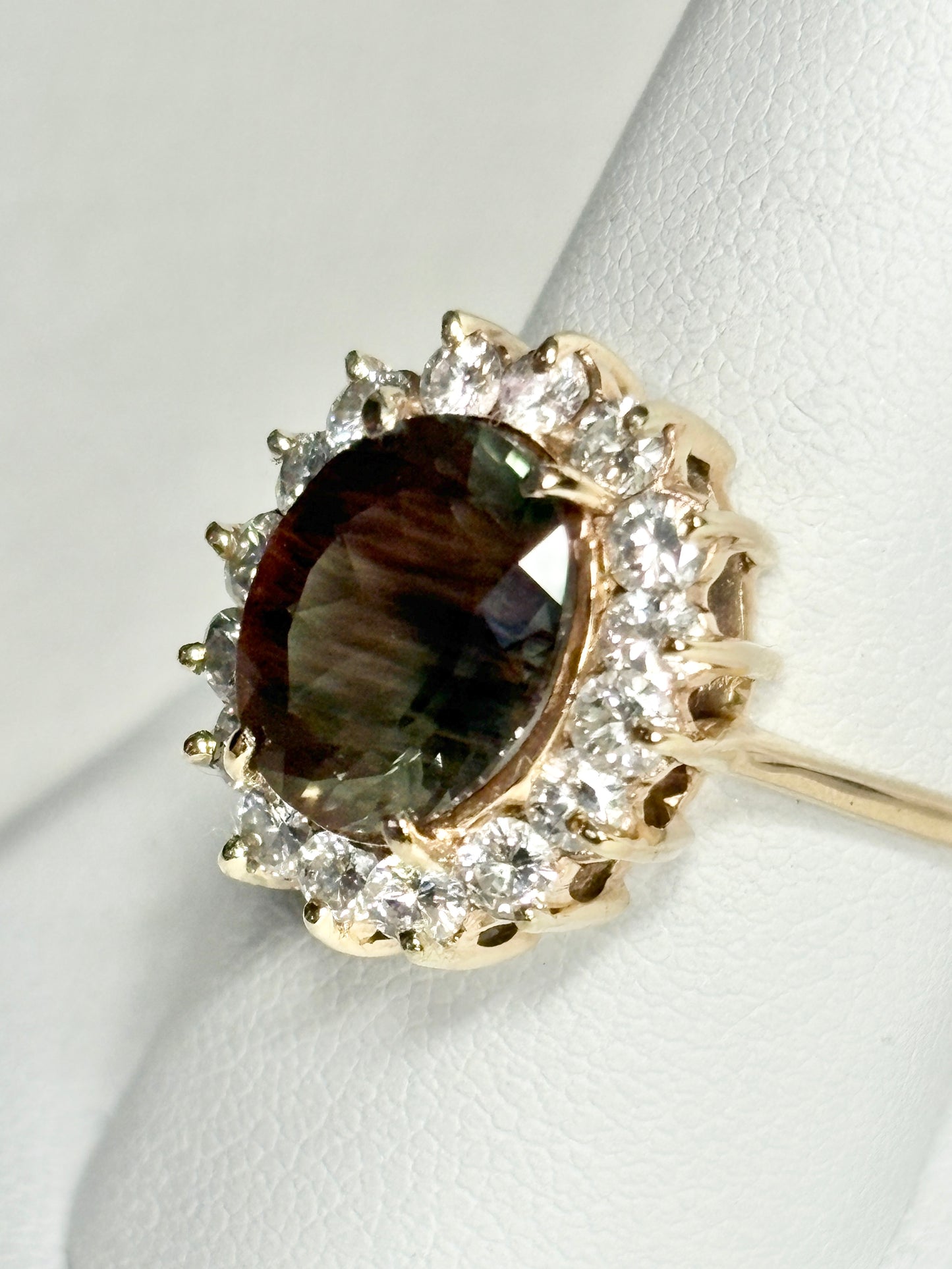 Oval dichroic Oregon sunstone ring with diamond halo in 14k gold.