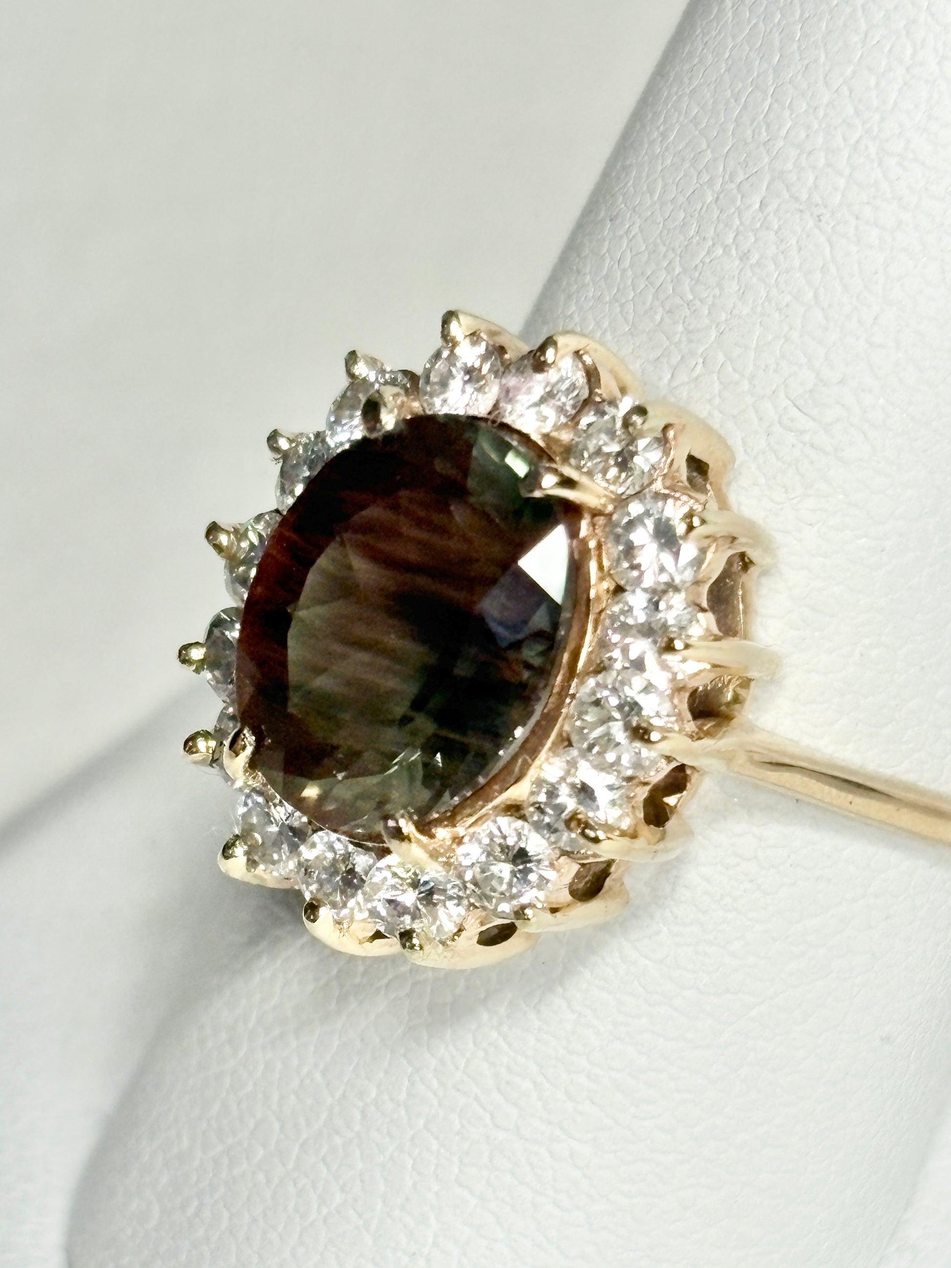 Oval dichroic Oregon sunstone ring with diamond halo in 14k gold.