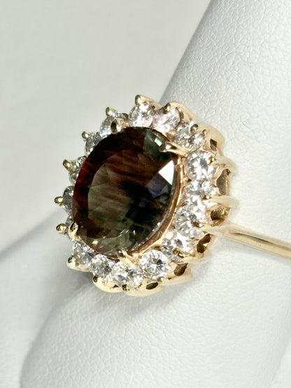 Oval dichroic Oregon sunstone ring with diamond halo in 14k gold.