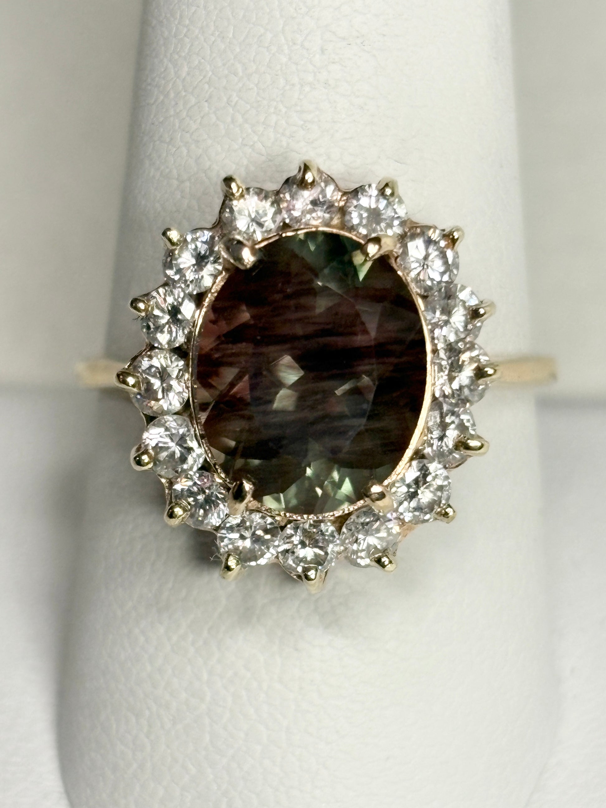 Oval dichroic Oregon sunstone ring with diamond halo in 14k gold.