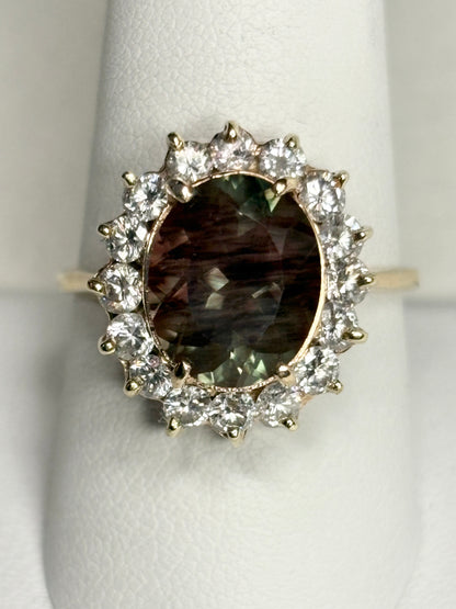 Oval dichroic Oregon sunstone ring with diamond halo in 14k gold.