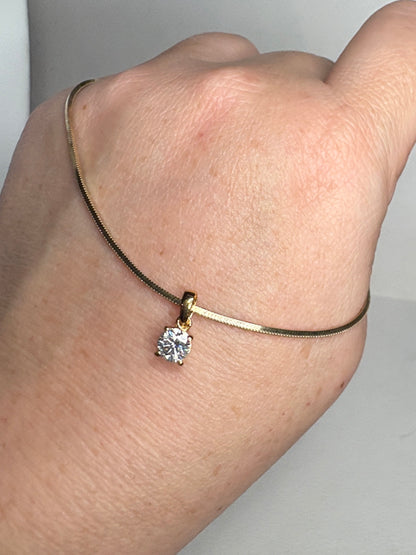 Gold over sterling silver snake chain necklace with a moissanite solitaire pendant.