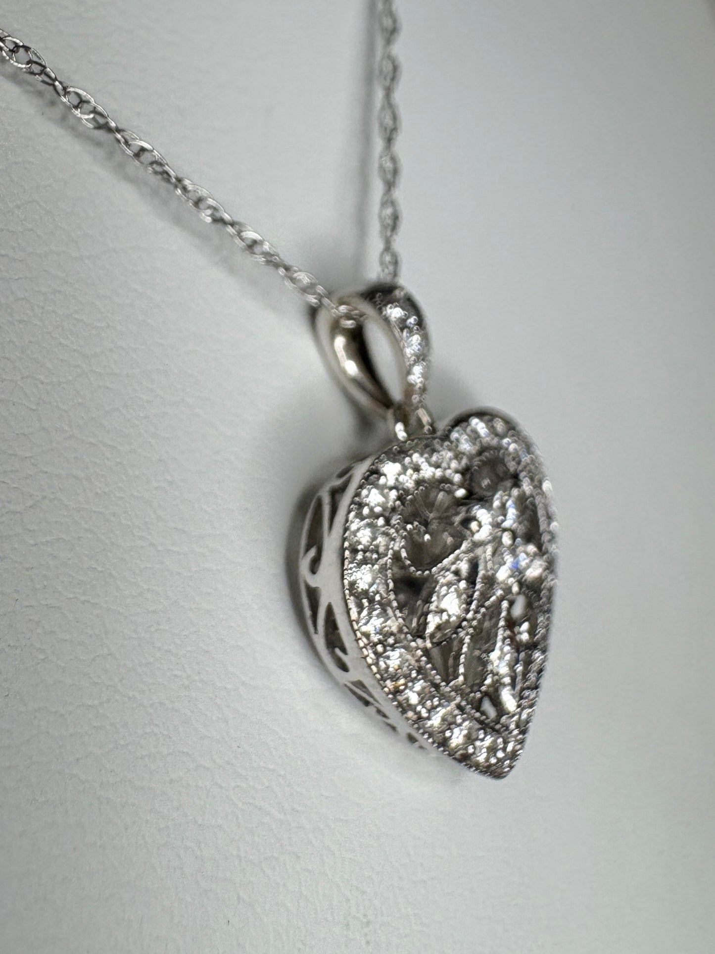 A diamond-encrusted heart pendant necklace in 14k white gold.