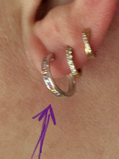 Sterling silver huggie hoop earrings with multi-color sapphires.