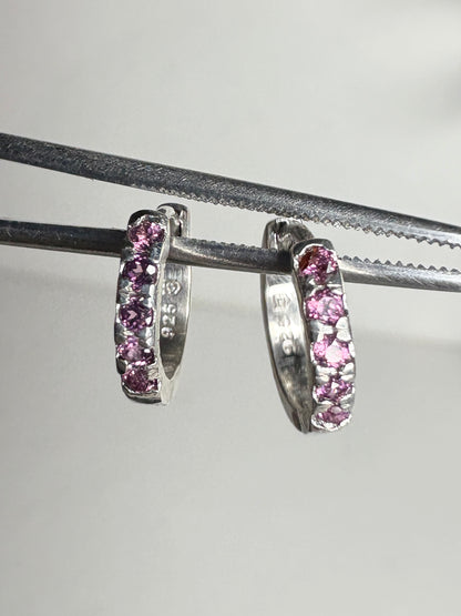 Small sterling silver huggie hoop earrings with rhodolite garnets.