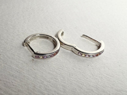 Sterling silver huggie hoop earrings with princess-cut multi-color sapphires.