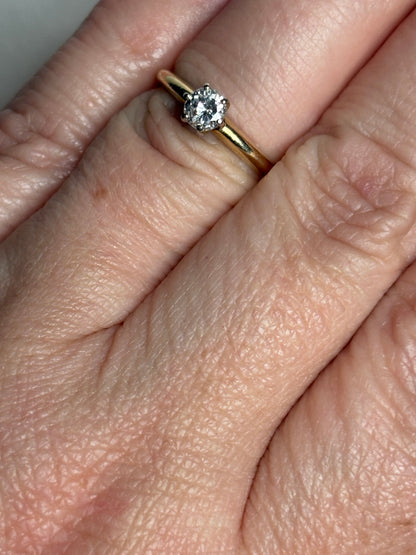 A 14k gold ring with a 0.28ct diamond set in white gold prongs.