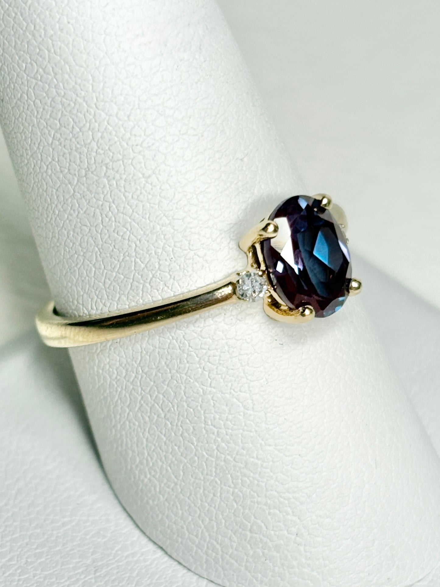 Oval lab-grown alexandrite and diamond ring in 10k gold.