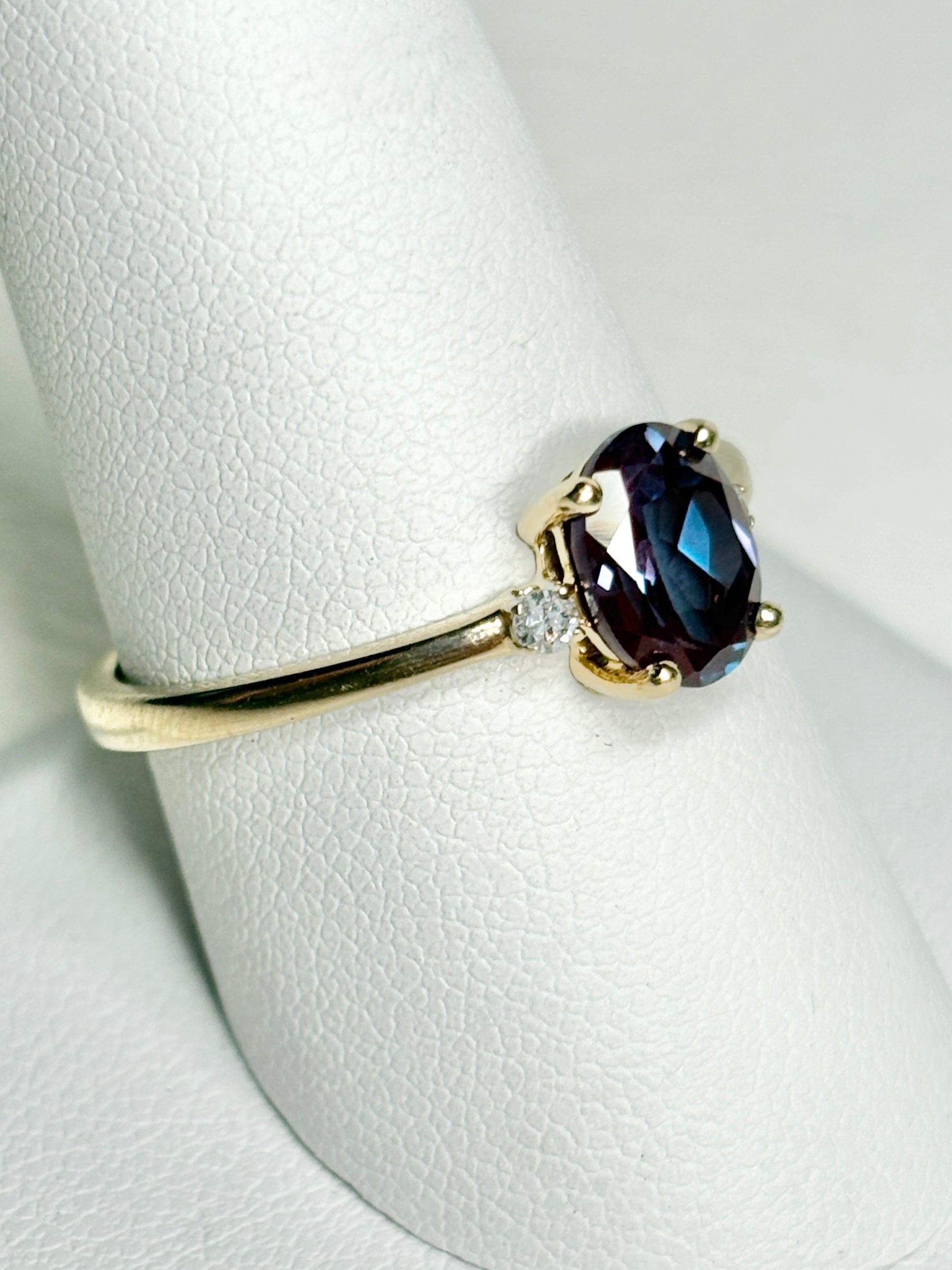 Oval lab-grown alexandrite and diamond ring in 10k gold.