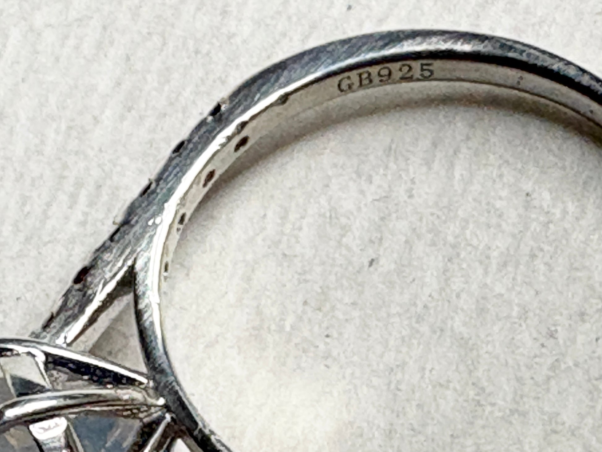 Sterling silver ring with "GB925" stamp and small stones.