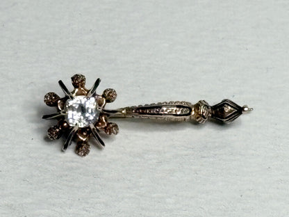 Antique 14k gold brooch pin with a central paste gem and enamel detailing.