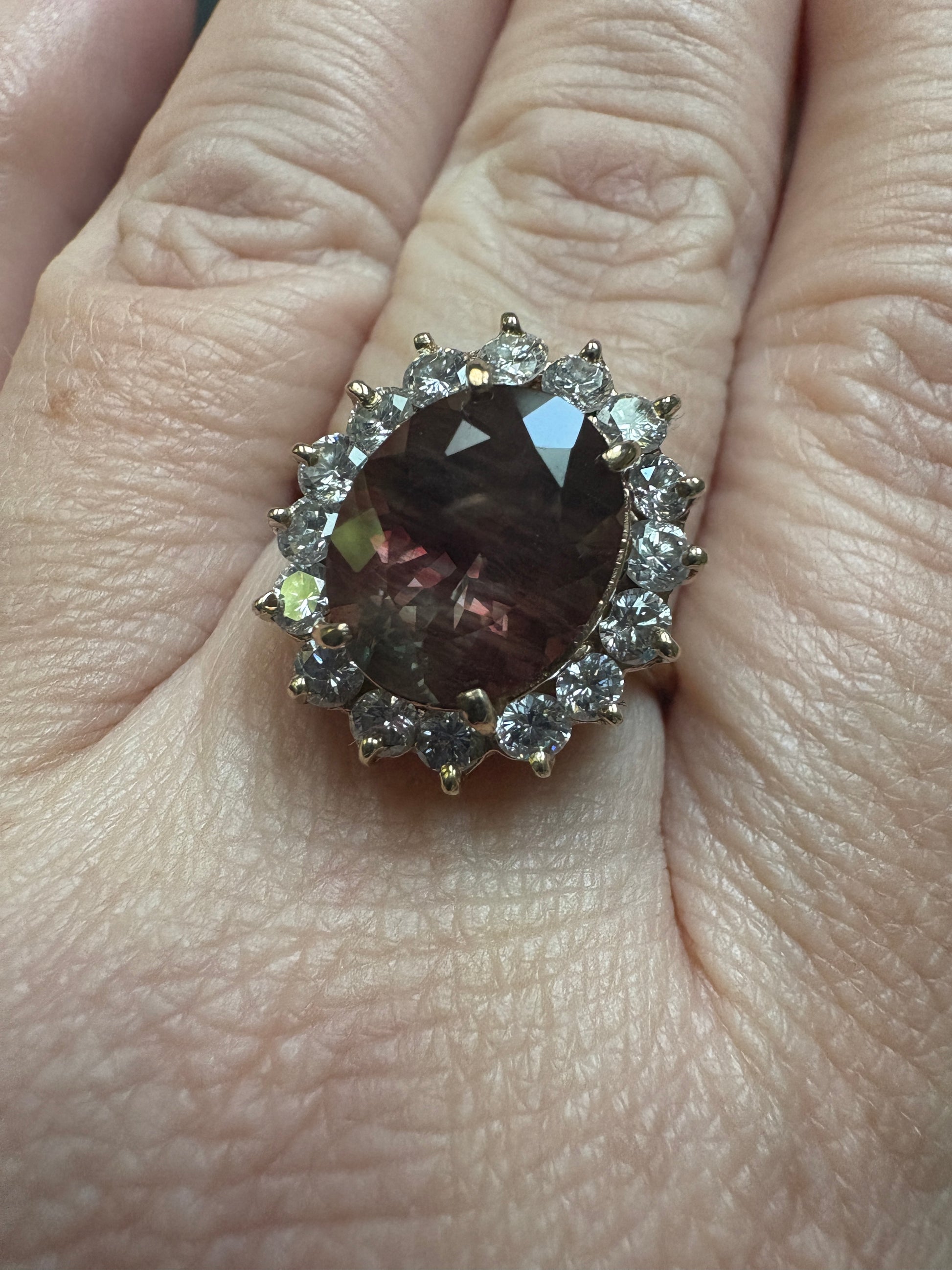 Oval dichroic Oregon sunstone ring with diamond halo in 14k gold.