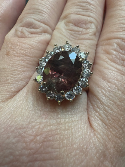 Oval dichroic Oregon sunstone ring with diamond halo in 14k gold.