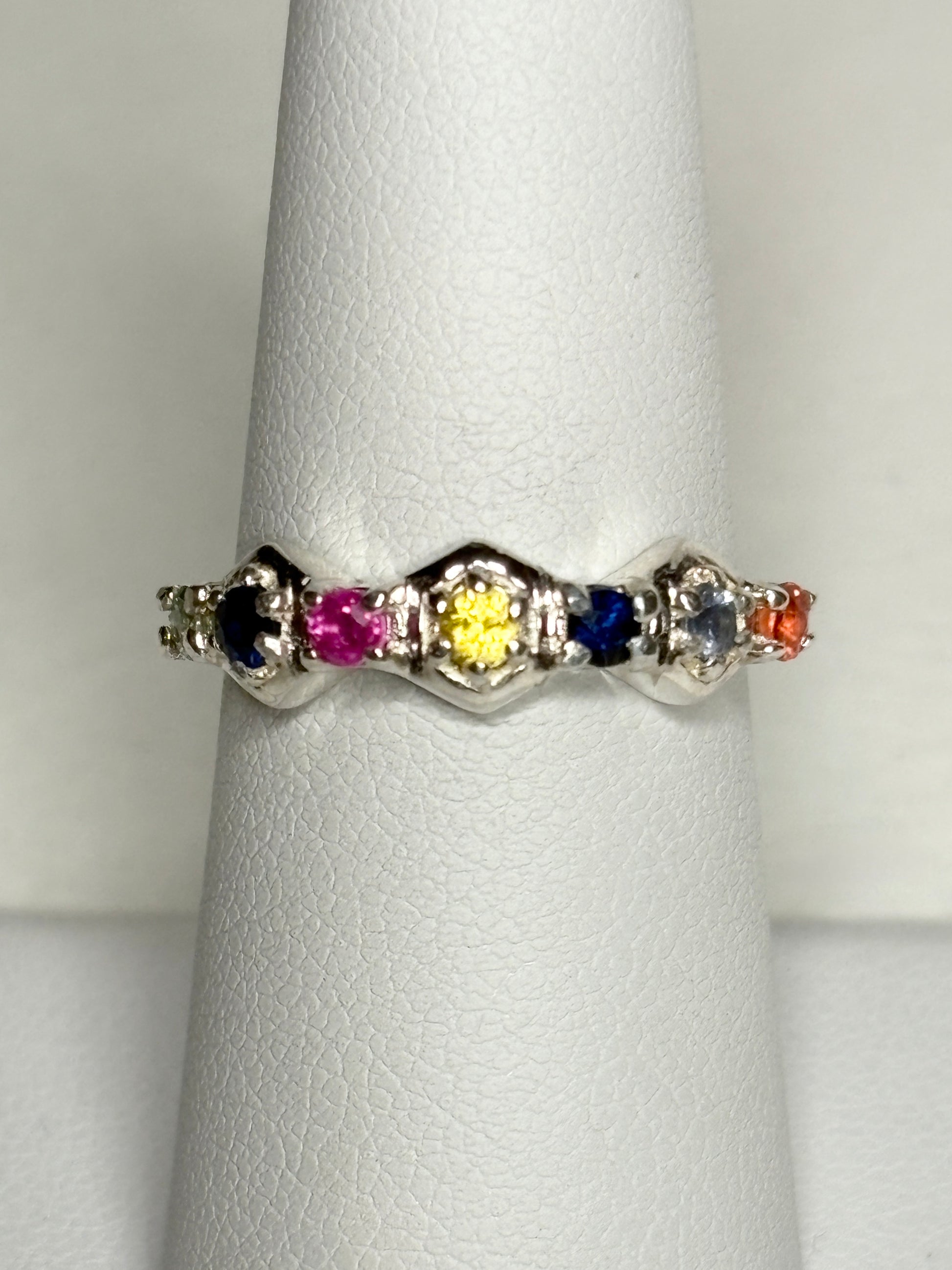 Sterling silver band ring with honeycomb shapes and multi-colored sapphires and ruby.