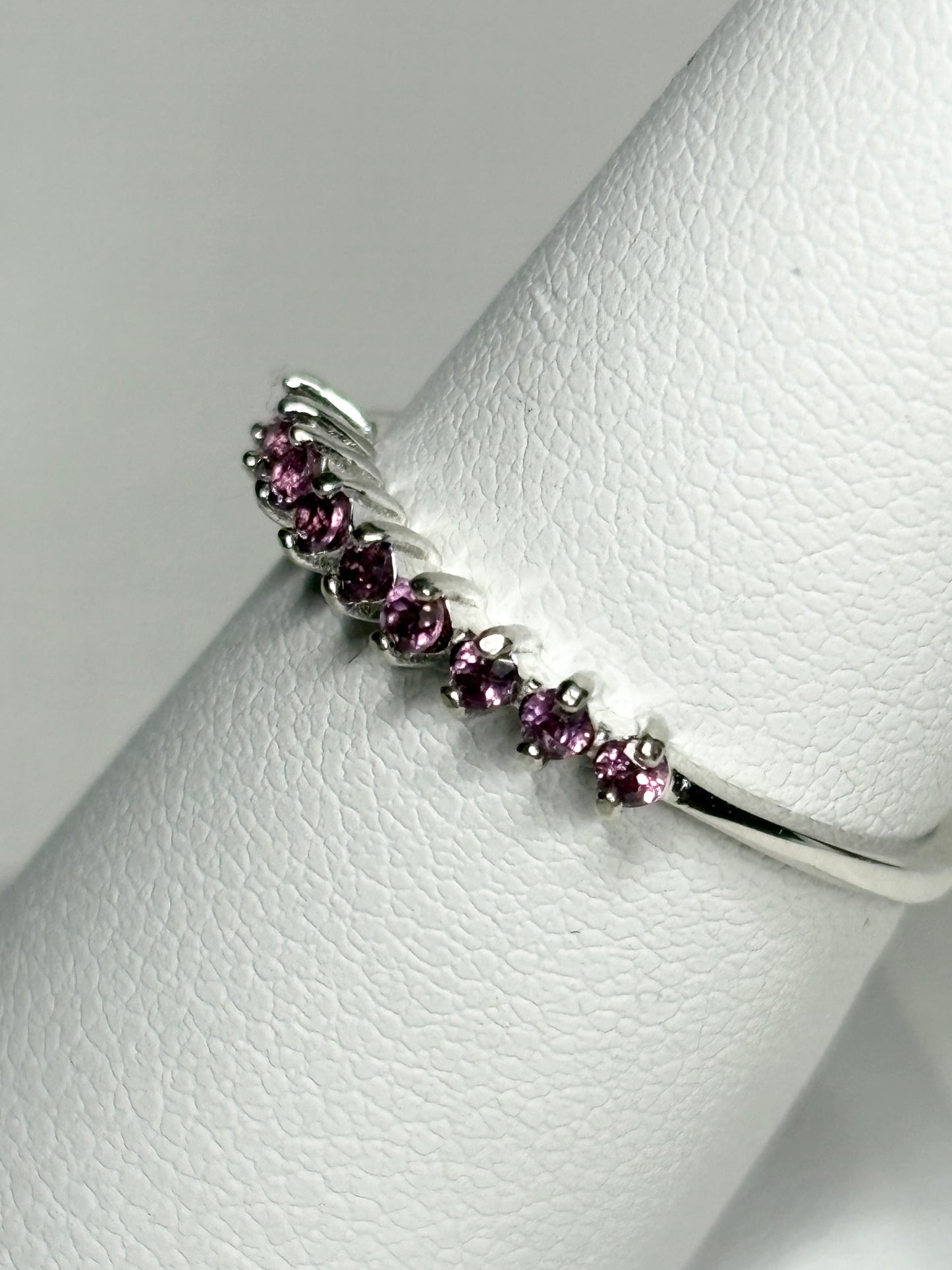 Sterling silver band ring with small rhodolite garnets.