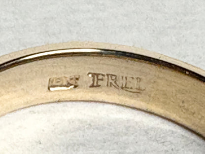 18k gold ring with channel-set diamonds and emeralds and milgrain detail.