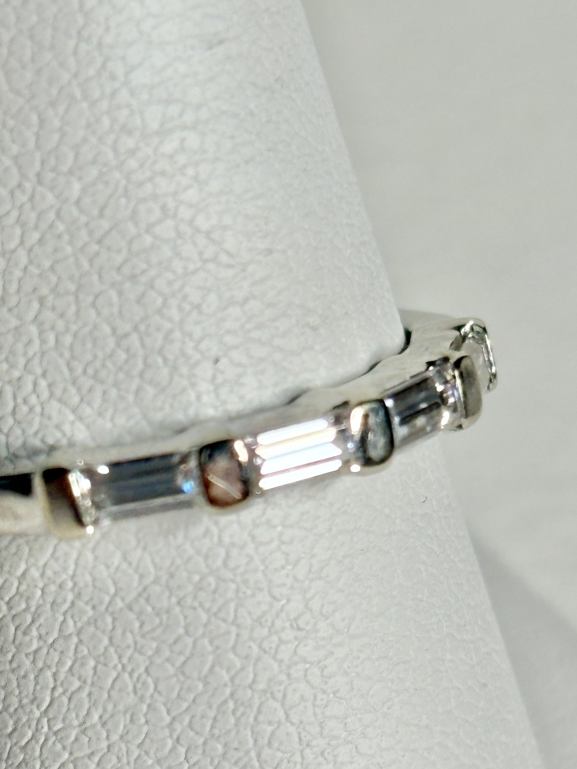 A 14k white gold band ring with baguette moissanite stones.