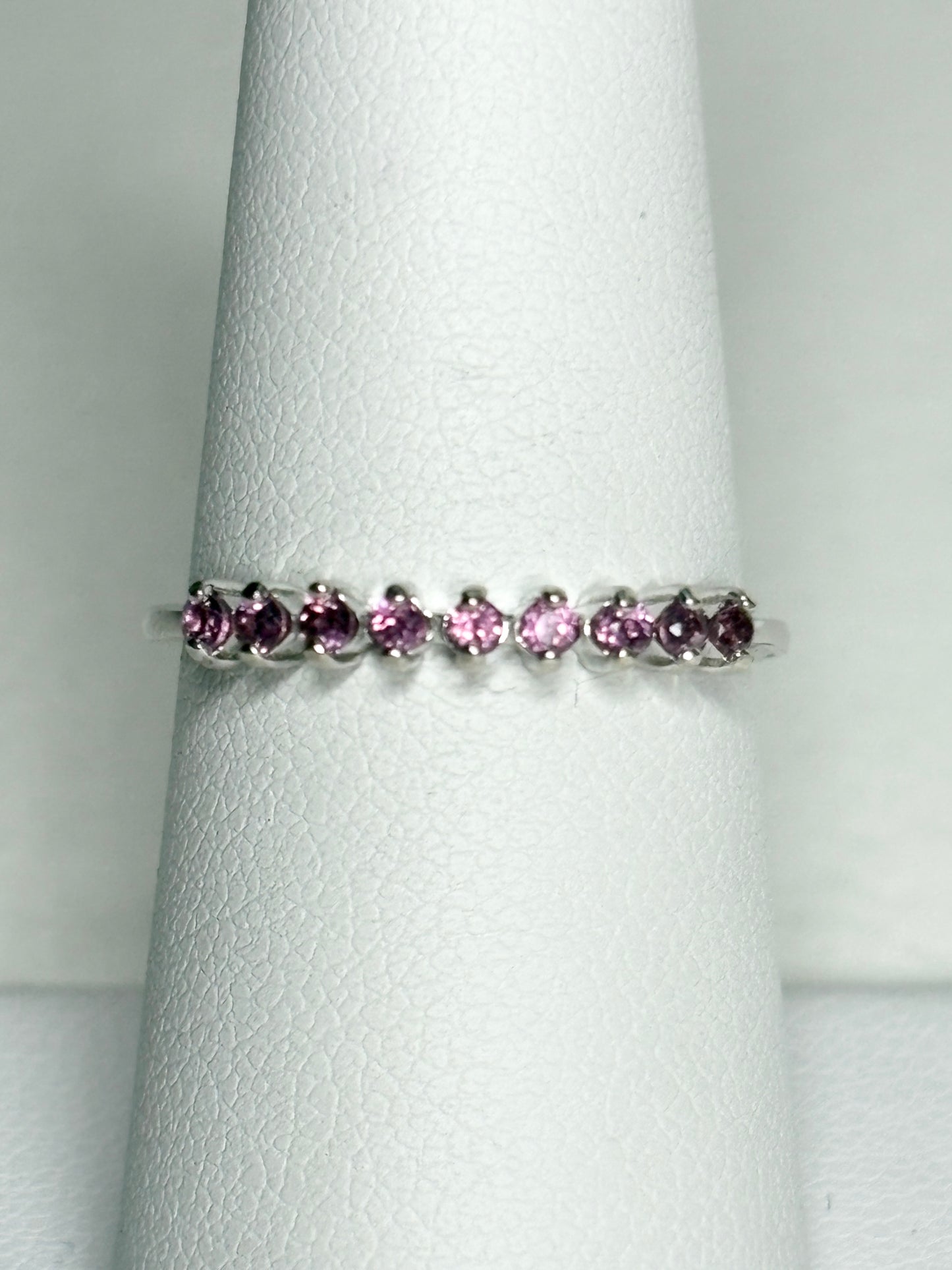 Sterling silver band ring with seven small rhodolite garnets.