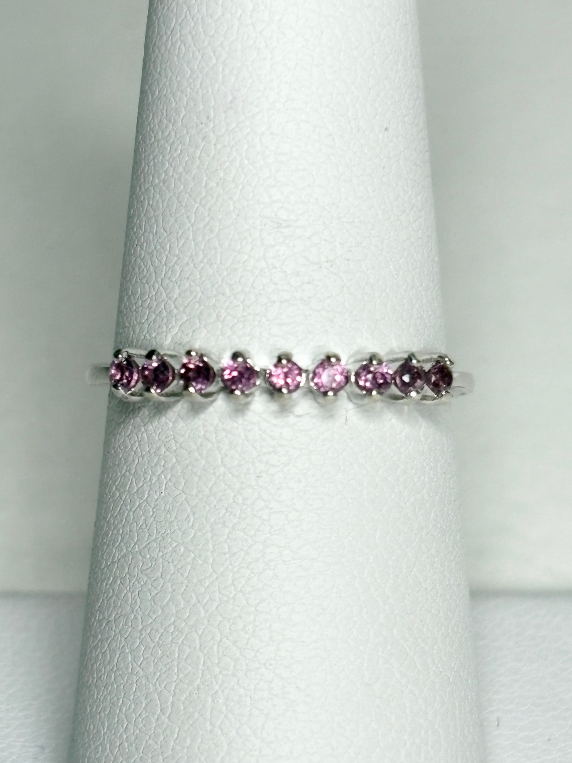 Sterling silver band ring with seven small rhodolite garnets.