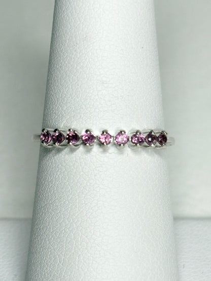 Sterling silver band ring with seven small rhodolite garnets.